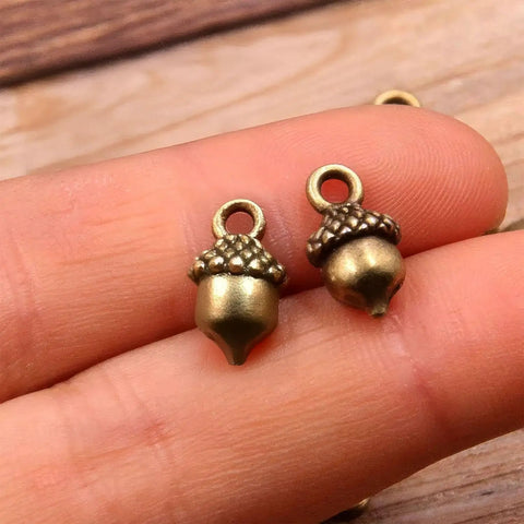 Hella Slick Screw Open Miniature Black Ebony Acorn Curios Set Of Two With Hidden Antique Bronze Pinecones close-up of bronze acorns.