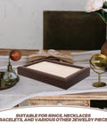 Solid Wood Earring Organizer And Ring Keeper Tray With Thirty Open Slots For Stashing Bracelets And Chains In A Rich Walnut Finish on a table.