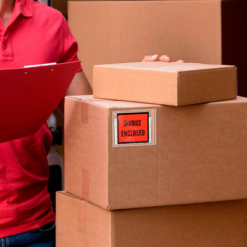 Top Shelf 4x5 Packing List Envelopes With Red Invoice Face and Easy Peel Seal Closure attached to stacked brown boxes.