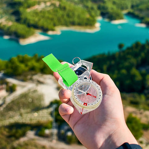 Hand holding Trail-Ready Outdoor Pocket Compass Thumb Navigation Tool for Hiking, Orienteering, and Map Reading