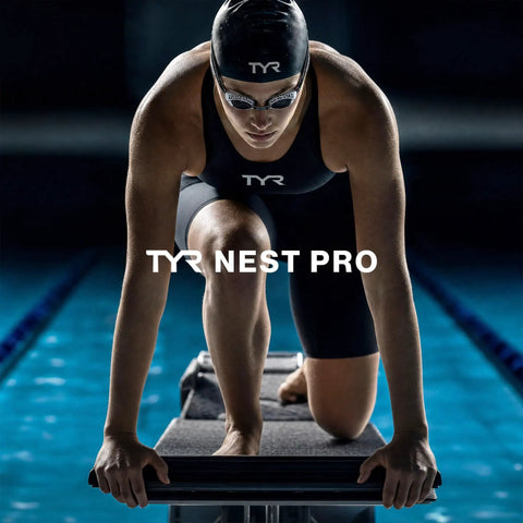 Crush The Daily Lap Grind With These Nest Frame Swim Goggles Locked In With Smoke Tint Wide Peripheral Vision And Tough Unibody Construction For Peak Pool Visibility. Swimmer on starting block ready for dive.