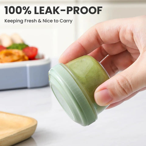 Close-up of hand holding green sauce cup from Eight Pack 2 Oz Salad Dressing Containers To Go With Lids For Lunch Boxes And Bento.