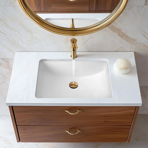 Overhead view of undermount white rectangular ceramic bathroom sink with overflow and durable glazed finish installed in wooden vanity.