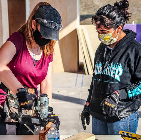 Two people wearing General Utility Spandex Work Gloves Black Large Pair With Padded Palm Rubberized Knuckle Protection.