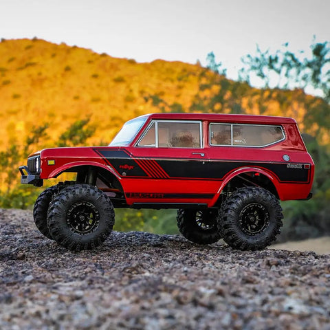 Redcat Racing Ascent 18 Scout II Brushless 4x4 RC Crawler on rocky terrain, aluminum chassis, red gold dust finish