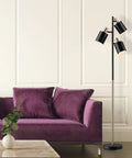 Annecy 58 Inch Rustic Floor Lamp With 3 Lights, Dark Bronze Finish, beside a purple sofa in a modern living room.
