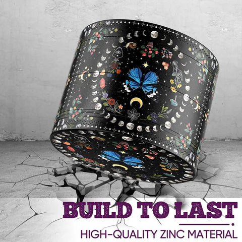 Black spice grinder with celestial design and text 'Build to Last' in purple, showcasing durability on cracked surface