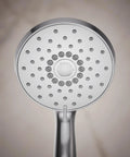 Close-up of Forté Four-Function Handshower in polished chrome, showing spray nozzles for full coverage, pulsating massage, and silk spray.