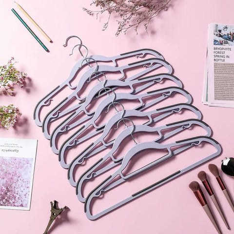 Hella Solid Premium Quality 50 Pack Plastic Clothes Hangers With Non Slip Rubber Edges For Heavy Duty Wardrobe Storage Space Saving Closet Organizer, purple hangers arranged on pink surface.