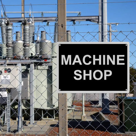 Top Tier Weatherproof Osha Machine Shop Sign 8X12 Inches on a fence beside machinery, emphasizing safety compliance outdoors.