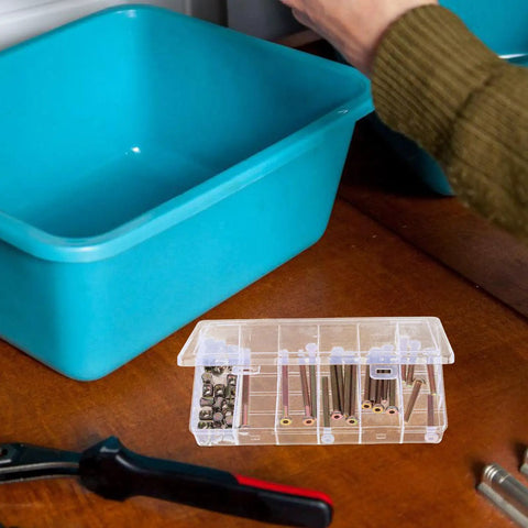 Open box of 49 Piece M6 x 40 to 80 Mm Hex Socket Screws And Barrel Nuts Kit on tabletop next to blue container and tool.