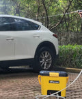 Using Compact Portable Pressure Washer With 5 Gallon Tank And 255 Psi For Easy Car Washes in a driveway setting.