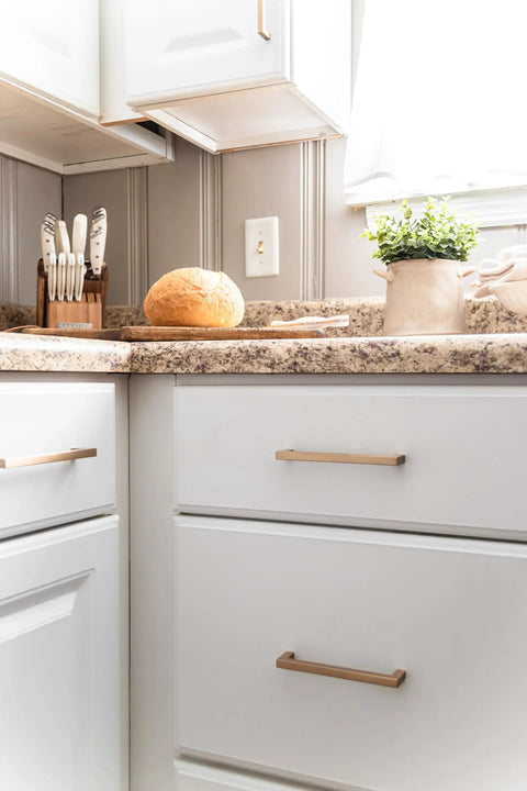 Kitchen with 12 inch solid core cabinet pulls in champagne bronze from Skylight Collection pack of 5 on white drawers