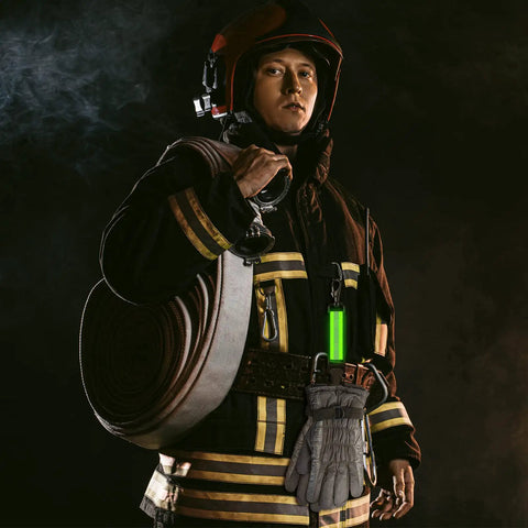 Firefighter wearing gear with Two Pack Firefighter Glove Straps with Reflective Trim and High Visibility Green clip