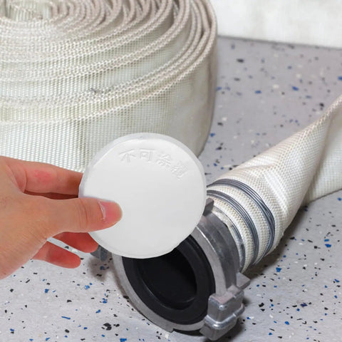 Sleek Iron Fire Sprinkler Nozzle Cover Plate With Tough Head Protector And Snug Ceiling Escutcheon To Mask Annoying Holes while showing a white circular plate near a hose.