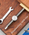 Top Shelf Heavy Duty Brass And Aluminum Workbench Vice For Woodworking Tables Featuring Rust Resistant Stainless Steel Jaws Compact Fit Wide Grip Setup Real Deal secured on wood surface with wrench.