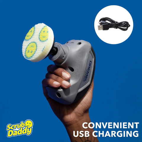 Hand holding Versa Power Scrubber Grout Brush And Shower Cleaning Tool with USB charging cable in the background.