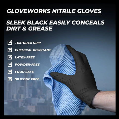 Close-up: GloveWorks black nitrile glove on hand gripping a blue textured microfiber cleaning cloth for cleaning tasks