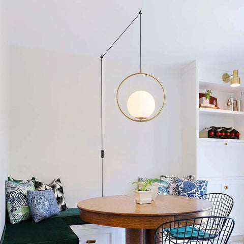 Plug In Globe Pendant Light Fixture With White Glass Ball And Brushed Brass Ring in modern kitchen setting