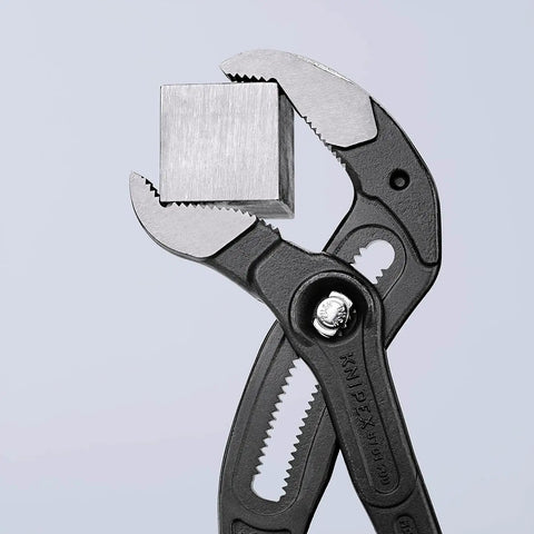 Water Pump Pliers Cobra XL 400 Mm Self Locking gripping a metal block, showcasing its quick push button adjustment feature.