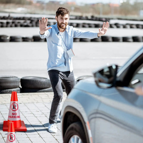 Man directing traffic with six pack 18 inch no parking reflective traffic cones with 360 reflective collars in parking lot.