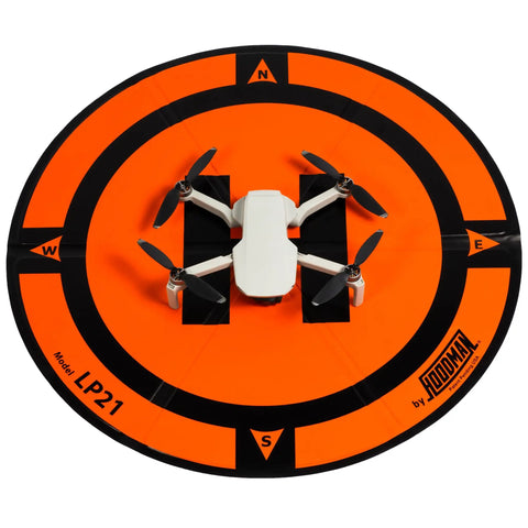 Mini drone on Weighted Trifold UAV Drone Landing Pad LP21, orange with black stripes, stakes-free and stable on turf.