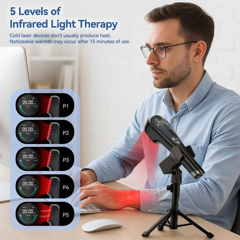 Man using handheld red light therapy device with stand for muscle recovery at desk, showcasing settings for infrared therapy levels.