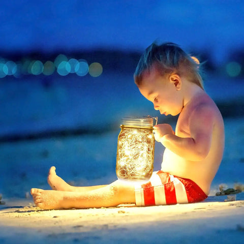 Child holding jar with Warm White LED Glow Candle With 12 Hour Illumination, Realistic Flicker, Long-Lasting Battery Powered Decor Light