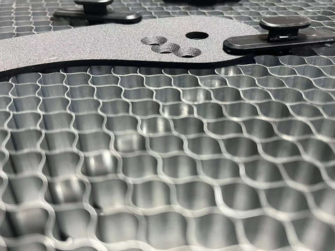 Close-up of metal honeycomb plate with fixing pins for laser cutting/engraving machines