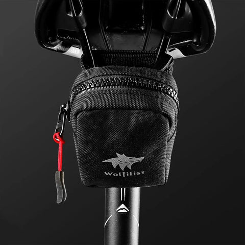 Compact under seat cycling saddle bag for road bikes with easy access zipper, durable and water resistant material.