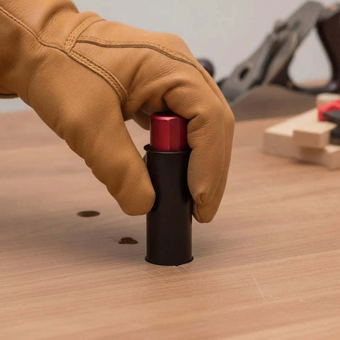 Using Retractable Table Stop For Woodworking Benches, black metal body, 19mm diameter, being pressed down with gloved hand.