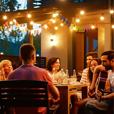 Outdoor string lights 150 ft with 75 shatterproof G40 globe bulbs illuminating a backyard gathering at dusk.