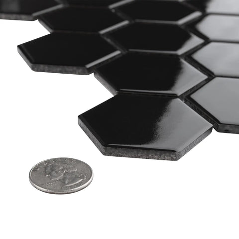 Dope Glossy Black Porcelain Hex Mosaic Tile For Floors And Walls, Mesh-Mounted 2 Inch Pieces next to a coin for size comparison