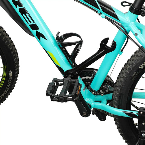 Close-up of a mountain bike pedal and chain area with turquoise frame, featuring rugged tires and black pedal detail.