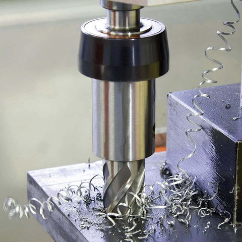 Annular cutter in magnetic drill, close-up view; silver high-speed steel tool with spiral flutes and metal shavings