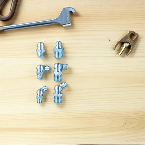 Get Your Hands On This Awesome 100pcs Grease Fitting Assortment Kit Featuring Hexagon 1/8-28 Thread Zerk Nipples In Straight And 45 Angled Galvanized Iron For Serious Workshops And Routine Machinery Maintenance. Straight and angled galvanized grease fittings on wood surface