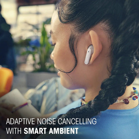 Woman wearing Tune Flex 2 True Wireless Earbuds With Active Noise Cancellation And Spatial Sound, enjoying music in ambient setting.