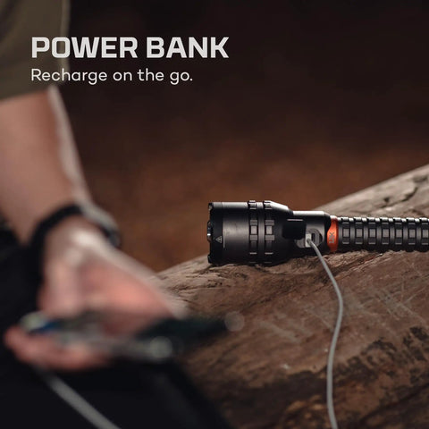 12K Lumen Flashlight With Built In USB Power Bank on log, charging a device, rugged outdoor use, rechargeable USB C dual zoom.