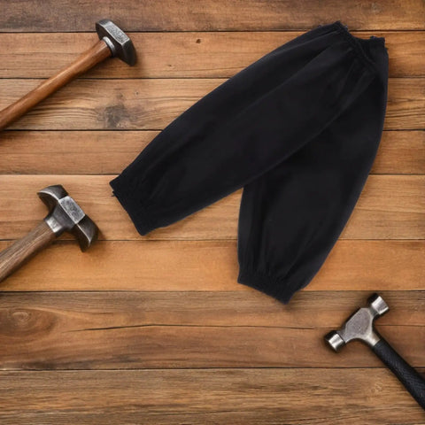 Heavy Duty Waterproof PU Arm Sleeves Extended Length Oversleeve Protectors Tough As Nails For Grease And Grime No Sweat Reusable Oil Water Resistant Gear For Messy Kitchen Cooking And Garage Work Pack Of Two Black on wooden surface with hammers.