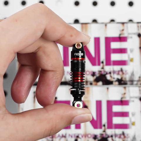 Hand holding 51mm Oil Filled Dual Spring Shocks With CNC Long Threaded Dampers For TRX4M TRX4MT 1/18 RC Crawler Upgrades