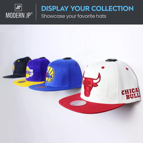 Killer 16 Pack Adhesive Hat Hooks For Wall Setup With Zero Hassle And Savage Strong Hold Perfect For Baseball Caps And Fitted Hats hanging four colorful caps on a white wall.