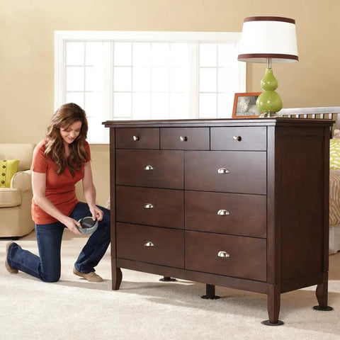 Woman installing 5 Inch Round Multi Surface Furniture Sliders For Carpet And Hard Floors With Removable Hardwood Socks under dresser.