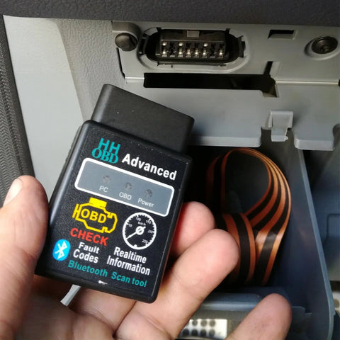 Bluetooth OBD2 Scanner For Cars With Real Time Diagnostics Read And Clear Engine Fault Codes Wireless Code Reader Tool Pro Grade Auto Diagnostic Adapter For Universal Vehicle Compatibility And Easy Car Troubleshooting held in hand near car port