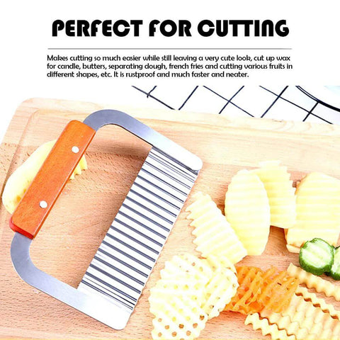 Stainless steel wavy crinkle cutter with orange wooden handle, front view on cutting board beside crinkle-cut potatoes.