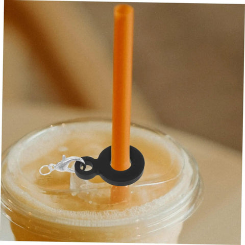 Close-up of a black silicone straw charm on an orange straw in a drink lid. Six Piece Set Straw Charms For Tumblers And Cups Cute Dangle Toppers.