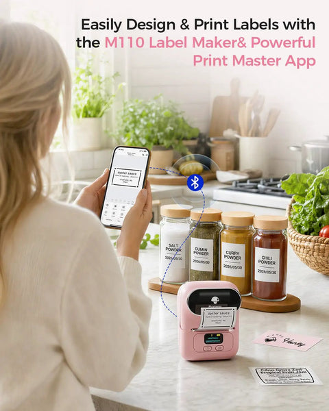 No Sweat Portable Thermal Label Printer With Crisp Built In Display And Smartphone App Hookup For Home And Small Business Quick Print Name Tags Price Stickers Cable Wraps Jewelry Cards Up To Fifty Millimeters Wide in use next to labeled spice jars.