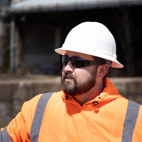 Construction worker wearing Tinted Safety Glasses 12 Pack ANSI Z87 Plus UV Eye Protection for outdoor work and industrial safety.