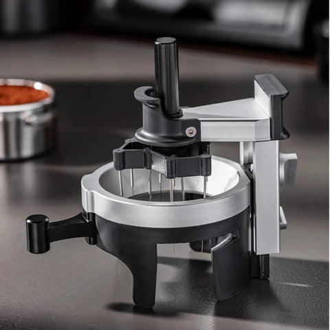 Heavy Hitter Rotary Espresso Puck Distributor Tool Featuring Adjustable Height And 12 Precision Points To Crush Clumps Level Coffee Grounds Evenly Compact Barista Accessory For Home Daily Driver Setup close-up on a sleek silver and black design with rotary handle.