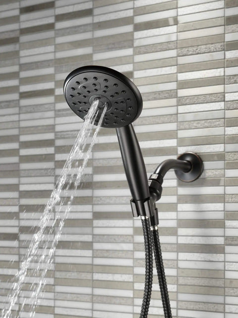 Porter 3 Setting Hand Shower Oil Bronze Finish Touch Clean Sprayer showing water flow against a textured tile wall.