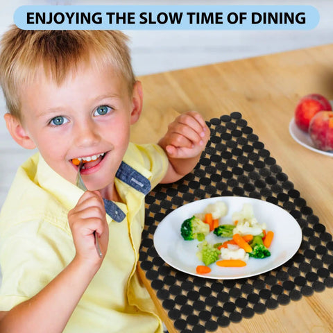 Child eating at table with black mat, featuring Two Pack Adjustable Kitchen Sink Mat With Fast Draining Design That Protects Dishes